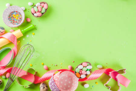Sweet baking concept for Easter, cooking background with baking - with a rolling pin, whisk for whipping, cookie cutters, sugar sprinkling, flour. Light green background, top view copy spaceの写真素材