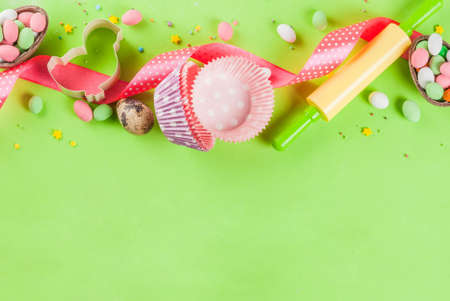 Sweet baking concept for Easter, cooking background with baking - with a rolling pin, whisk for whipping, cookie cutters, sugar sprinkling, flour. Light green background, top view copy spaceの写真素材