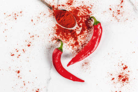 Raw fresh organic and dried ground chili pepper on white marble background top view copy spaceの写真素材