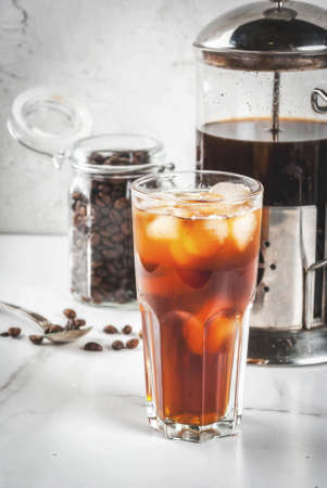 Trendy drinks. Cold brew iced coffee on white marble table. copy space