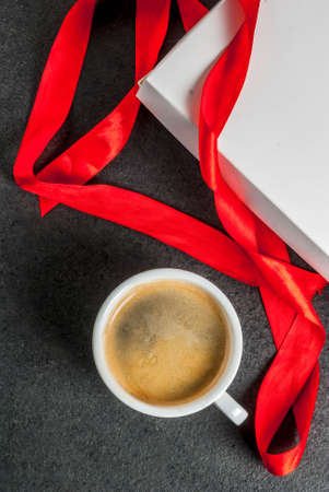 Valentine's day concept, gift box with red ribbon, coffee mug, black background, copy space top viewの写真素材