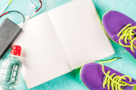 Sports, fitness concept. Running sneakers, water bottle, headphones, notebook, smartphone, on a light blue background top view copy spaceの写真素材