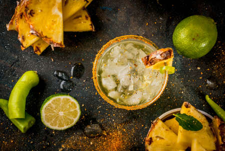 Mexican beverage, spicy margarita cocktail with pineapple and jalapeno and lime, dark blue background copy space top viewの写真素材