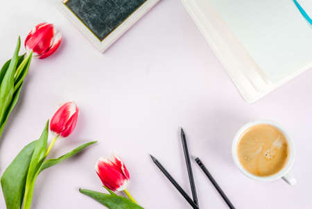 Valentines day background for congratulations, greeting cards. Fresh spring tulips flowers with notepad, coffee mug, on a white background top view copy spaceの写真素材