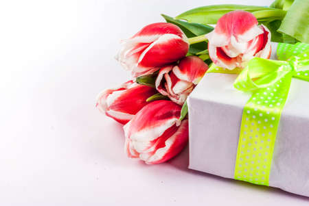 Spring concept. Flowers tulips on white background with coffee mug. Copy space, greeting card backgroundの写真素材