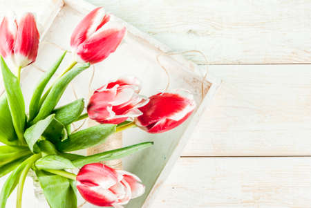 Spring concept. Flowers tulips in a glass mason jar, on wooden white background. Copy space top viewの写真素材