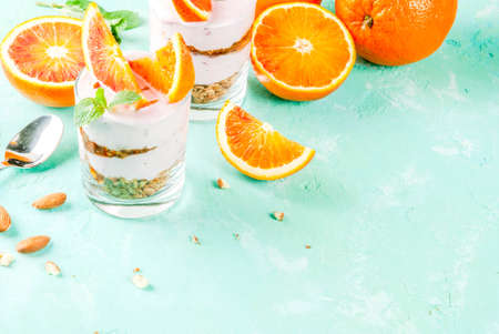 Healthy breakfast, Blood Orange Parfait with granola. yogurt, almond and mint, light blue background, copy spaceの写真素材