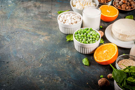 Healthy food concept. Set of food rich in calcium - dairy and vegan Ca products, dark blue background copy space の写真素材