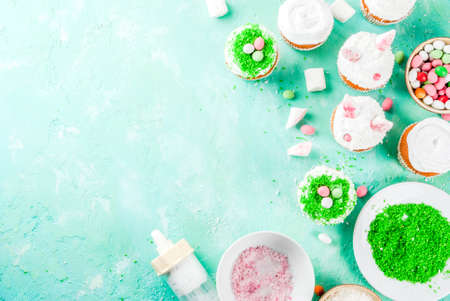 Making easter cupcakes with bunny ears and candy eggs, top view copy spaceの写真素材