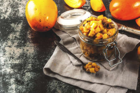 Traditional indian food recipes, Persimmon fruit Chutney with cinnamon and anise stars, dark rusty background copy spaceの写真素材