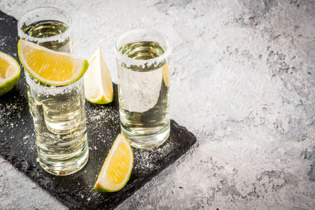 Tequila shots with lime and sea salt on grey stone table, copy spaceの写真素材