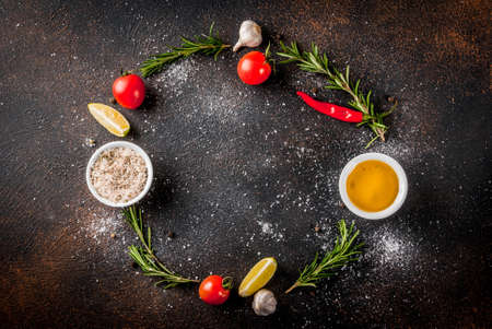 Food cooking ingredient, olive oil, herbs and spices, dark rusty background top view copy space frameの写真素材