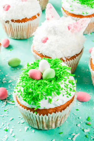Easter cupcakes with bunny ears and candy eggs, copy space