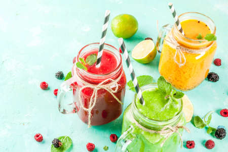Healthy fresh fruit and veggie smoothies with ingredients on light blue concrete table, copy spaceの写真素材
