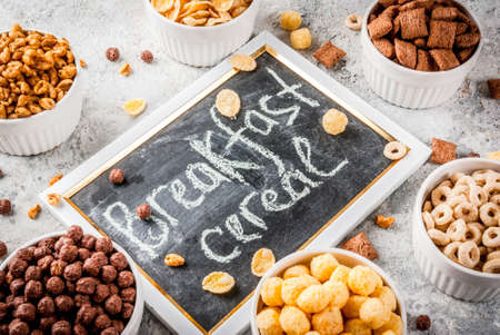 Set of various breakfast cereal corn flakes, puffs, pops, grey stone table copy spaceの写真素材