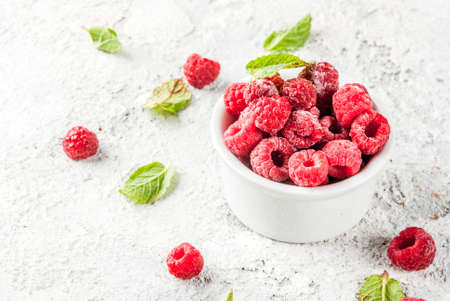 Fresh raspberries with mint in small bowl, on grey stone background, copy spaceの写真素材