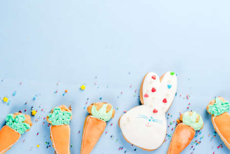 Easter holiday concept, sweet cookies in form of carrots, Easter bunny, with sweet sprinkles, light...