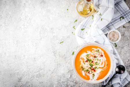 Trendy vegan food, Sweet Potato Detox Soup with coconut milk, dried tomatoes, peanuts and herbs, on grey stone table copy space top viewの写真素材