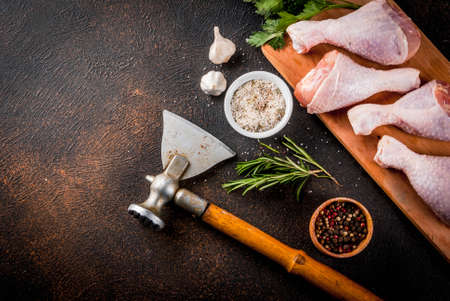 Raw meat, chicken legs, with herbs and spices n dark rusty background, copy space top viewの写真素材