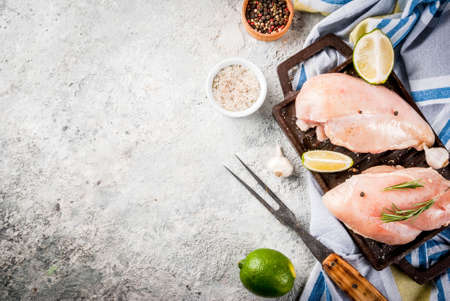 Raw meat, ready for grill or barbeque chicken breast filet, with olive oil, herbs and spices on grey stone background, copy space top viewの写真素材