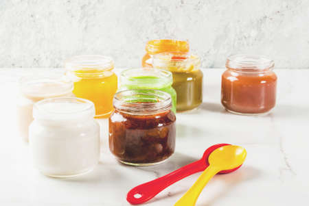 Variety of homemade baby vegetable and fruit puree,  white marble background copy spaceの写真素材