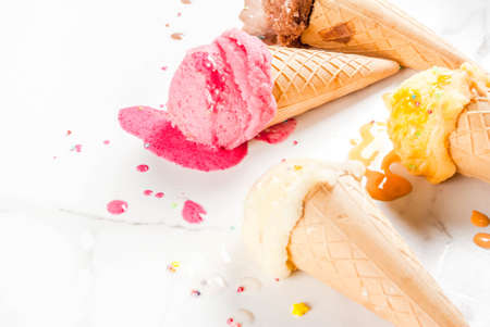Homemade berry vanilla caramel chocolate ice cream in waffle cones, white marble background copy...