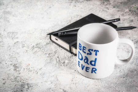 Father's Day concept, background for congratulating cards with a cup with the inscription Best Father ever, business notebook and pencils. copy spaceの写真素材