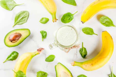 Healthy smoothie with banana and baby spinach, n white marble background copy space top viewの写真素材