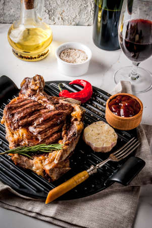 Fresh grilled meat beef steak with with red wine, herbs and spices. Top view copy space white marble backgroundの写真素材