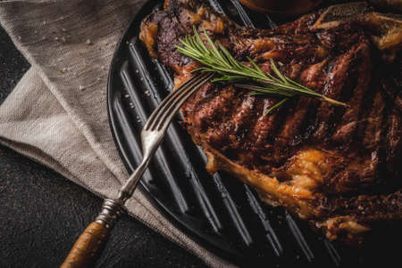Fresh grilled meat beef steak with with red wine, herbs and spices. Top view copy space dark rusty backgroundの写真素材