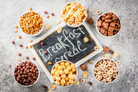 Set of various breakfast cereal corn flakes, puffs, pops, grey stone table copy space top viewの写真素材