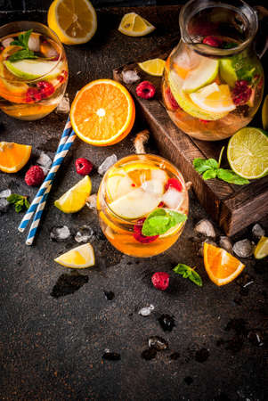 Summer cold cocktail, fruit and berry white sangria with apple, lemon, oranges and raspberry. dark background, copy space top viewの写真素材