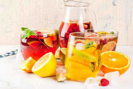 Summer cold cocktail, set of three fruit and berry sangria drink. red white pink, with apple, lemon, oranges and raspberry. light background, copy space の写真素材