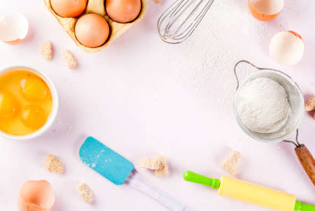 Ingredients and utensils for cooking baking egg, flour, sugar, whisk, rolling pin, on light pink...
