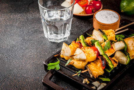 Vegan diet food, Grilled cheese and vegetables kebab, indian style Paneer Tikka, with white sauce and lime, on dark concrete background, copy spaceの写真素材