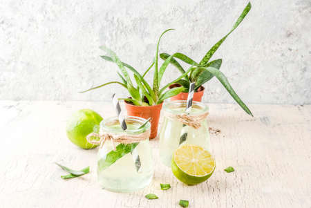 Healthy exotic detox drink, aloe vera or cactus juice with lime, on light concrete background copy spaceの写真素材