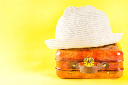 Summer vacation concept, bright yellow background with hat, sun glasses and bag (suitcase)の写真素材