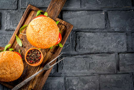 Homemade bbq beef meat sandwich burger with fresh vegetables copy space dark background top viewの写真素材