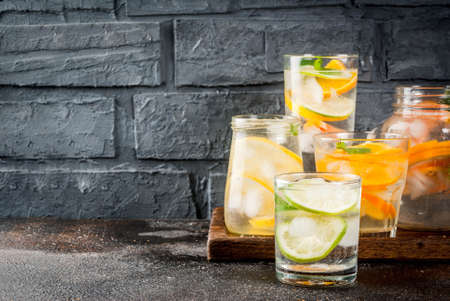 Summer healthy cocktails, set of various citrus infused waters, lemonades or mojitos, with lime lemon orange grapefruit, diet detox beverages, in different glasses dark background copy spaceの写真素材