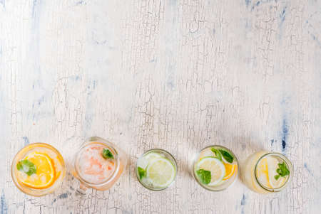 Summer healthy cocktails, set of various citrus infused waters, lemonades or mojitos, with lime lemon orange grapefruit, diet detox beverages, in different glasses light background copy space aboveの写真素材