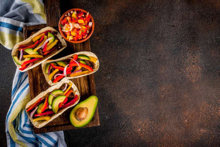 Homemade Mexican pork tacos with vegetables and salsa, on dark rusty table top viewの写真素材