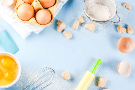 Ingredients and utensils for cooking baking egg, flour, sugar, whisk, rolling pin, on blue...
