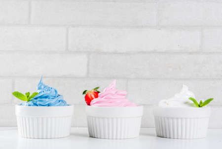 Healthy diet summer dessert, vanilla and berry frozen yogurt or  soft ice cream in white bowls,...