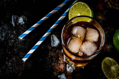 Cuba Libre, long island or iced tea cocktail with strong alcohol, cola, lime and ice, two glass, dark background copy space top viewの写真素材