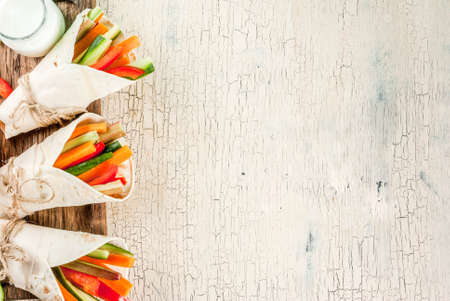 Summer healthy snack appetizer, Mexican style tortilla sandwich wraps assorted colorful fresh vegetable sticks (celery, rhubarb, pepper, cucumber and carrot) with yoghurt sauce dip aboveの写真素材