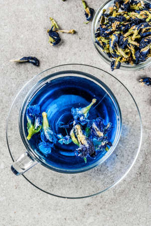 Healthy drinks, organic blue butterfly pea flower tea with limes and lemons, grey concrete background copy space top viewの写真素材