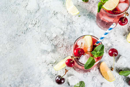 Summer iced refreshment drink, cherry cola lemonade or mojito cocktail in tall glass, on light blue...