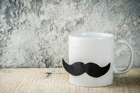 Happy Fathers day concept with coffee cup as father with mustache, grey concrete background copy spaceの写真素材
