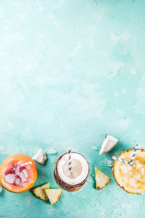 Summer holiday drink concept, set various tropical cocktails or juices in pineapple, grapefruit and...