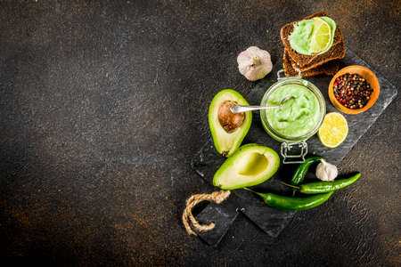Mexican food, guacamole with rye toasts sandwiches on dark background, copy space